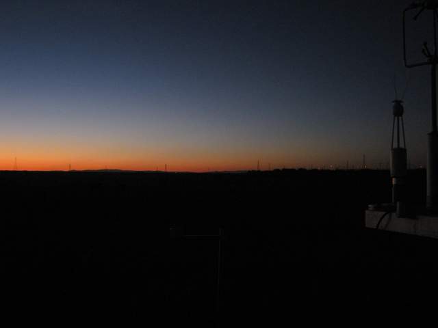 Cloudless sunset over cow pasture