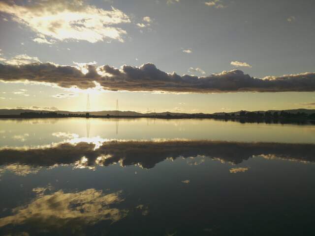 Clouds reflected in water near sunset