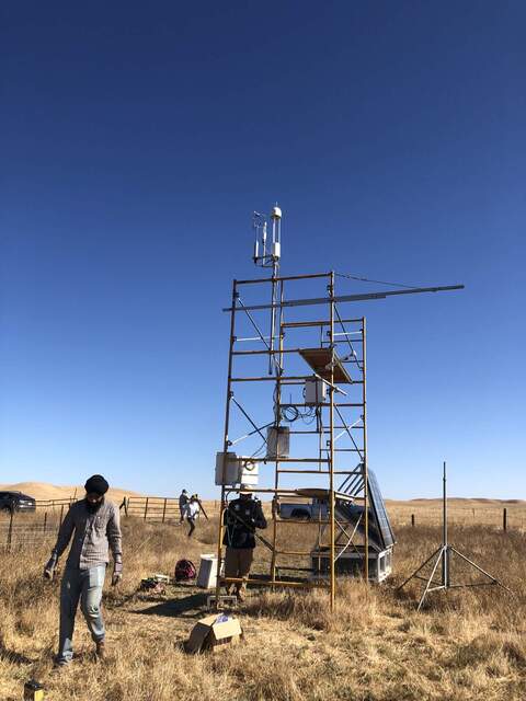 Arshdeep and Eddie working at the tower. Fresh eddy sensors installed on the west side of the scaffolding. The solar panels in the background are temporarily propped up to access the batteries below the platform.