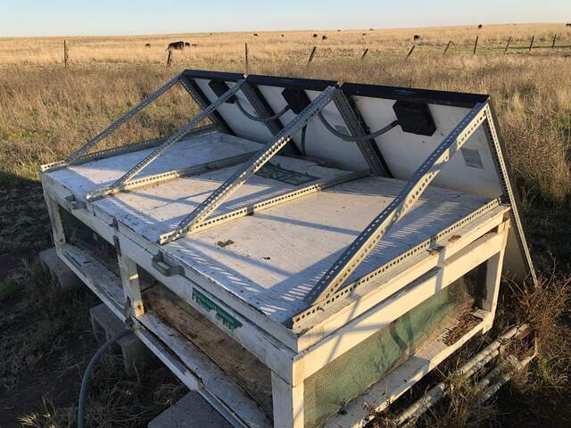 Solar panels have been secured to the L-brackets on top of the platform. The platform lid has been temporarily screwed shut to the bottom layer.