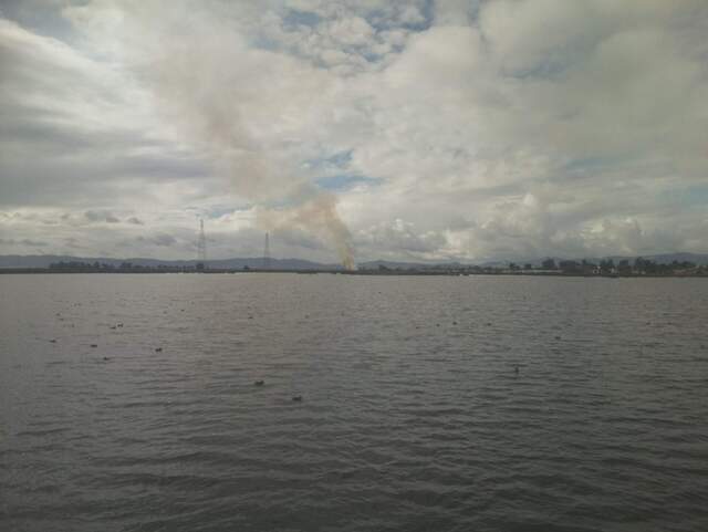 Smoke plume to the west over the water